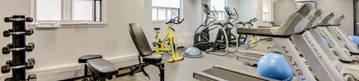 A well-equipped gym with a variety of exercise machines and weights.