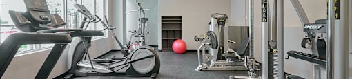 a gym with treadmills and other exercise equipment at Wesley Place Apartments in Vancouver British Columbia