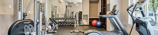 a gym with treadmills and other exercise equipment at Wesley Place Apartments in Vancouver British Columbia
