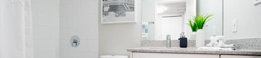 Wesley Place in Vancouver, BC White modern bathroom featuring shower tub