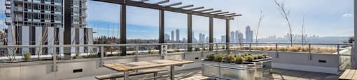 A sunny rooftop patio with a table and benches.