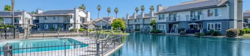 A swimming pool in front of a row of houses.