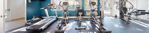 a fitness room with exercise machines and mirrors at The Marquee Apartments, North Hollywood, CA 91605