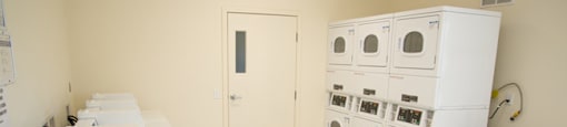 A laundry room with a white washer and dryer stacked on top of each other.