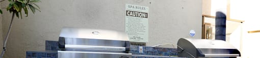 A stainless steel grill with a caution sign on the wall.