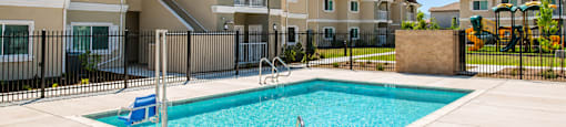A swimming pool in front of a row of houses.