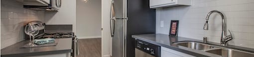 A kitchen with white cabinets and stainless steel appliances.