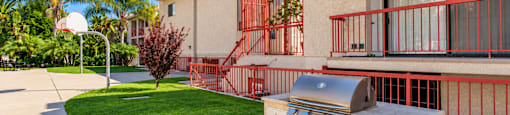 A red metal fence surrounds a small outdoor kitchen.