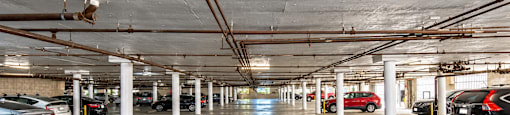 A spacious parking garage with multiple cars parked.
