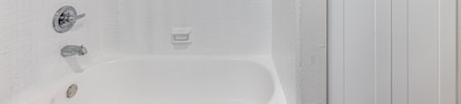 A white bathroom with a tub and a shower at The Marquee Apartments, North Hollywood 91605