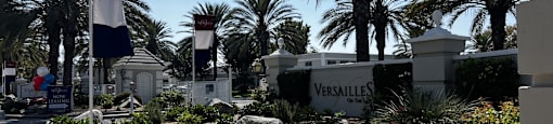 A garden with a Versailles sign in the background.