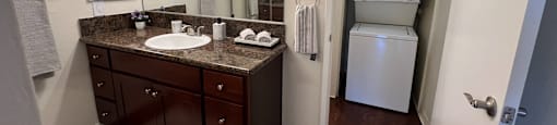 A bathroom with a brown vanity and a white towel.