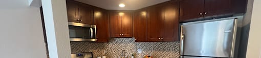 A kitchen with a refrigerator, microwave, and dishwasher.