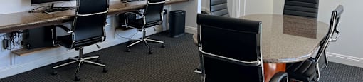 A conference room with a long table and chairs.