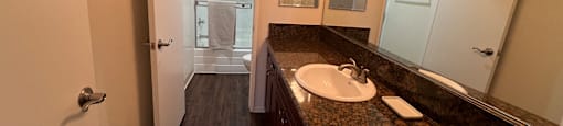 A bathroom with a sink, mirror, and a rug.