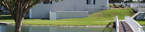 A white building with a tree in front of it.