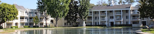 A large building with a pond in front of it.
