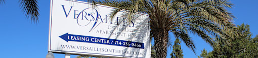 A Versailles Apartment Leasing Center sign is displayed in front of a building.