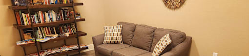 A living room with a couch, a coffee table, and a bookshelf.