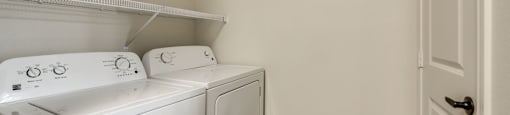A white washing machine and dryer in a small laundry room.