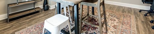 A dining room with a table, chairs, and shelves.