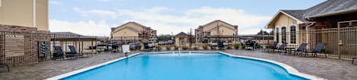 Large blue swimming pool in the middle of a residential area.
