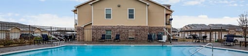 A swimming pool in front of a house.