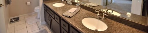 A bathroom with two sinks and a large mirror.