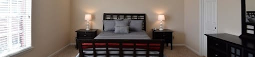 A bedroom with a bed, nightstands, and a ceiling fan.
