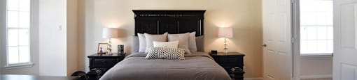 A bedroom with a bed, nightstands, and a ceiling fan.