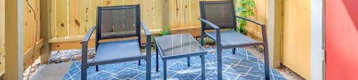 A small balcony with a table and two chairs.