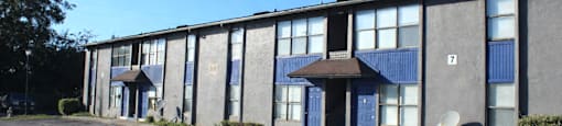 A grey building with blue doors and windows.