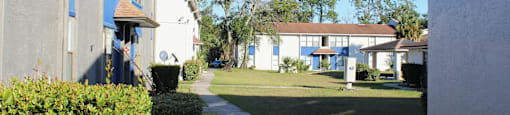 A sunny day in a quiet residential area with houses and trees.