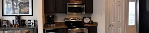 A kitchen with black cabinets and stainless steel appliances.