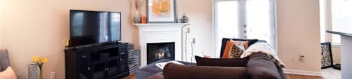 A living room with a brown couch and a fireplace.