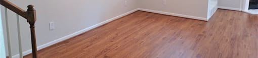 A room with wooden floors and a staircase.