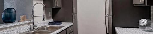 A kitchen with a sink and a refrigerator.