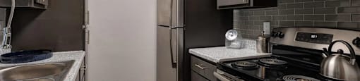 A kitchen with a black stove top oven and a black refrigerator.
