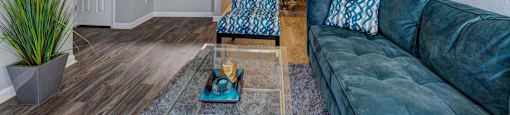 A living room with a blue couch and a wooden coffee table.