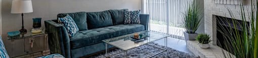A living room with a blue couch and a fireplace.