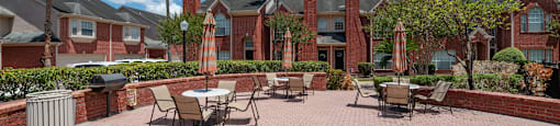 A patio with a table and chairs surrounded by a brick wall.