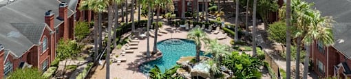 A pool surrounded by palm trees in a residential area.
