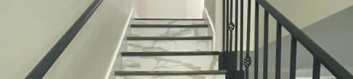 A staircase with a black railing and wooden steps.