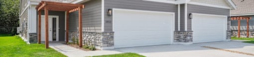 Twin Home with a white garage door and a driveway