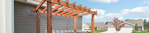 a wooden pergola at the entry to the twin home