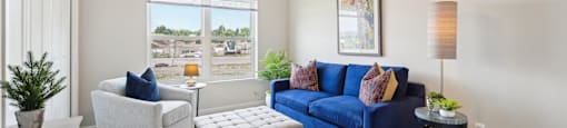 bedroom or den with a blue couch and chair and a ceiling fan