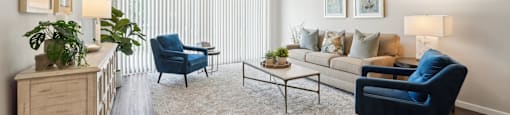a living room with a couch and two blue chairs
