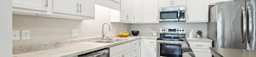 a kitchen with white cabinets and stainless steel appliances