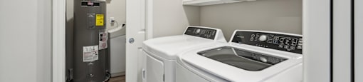 laundry with storage cabinets and a washer and dryer and a boiler
