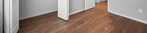 an empty living room with wood flooring and a ceiling fan